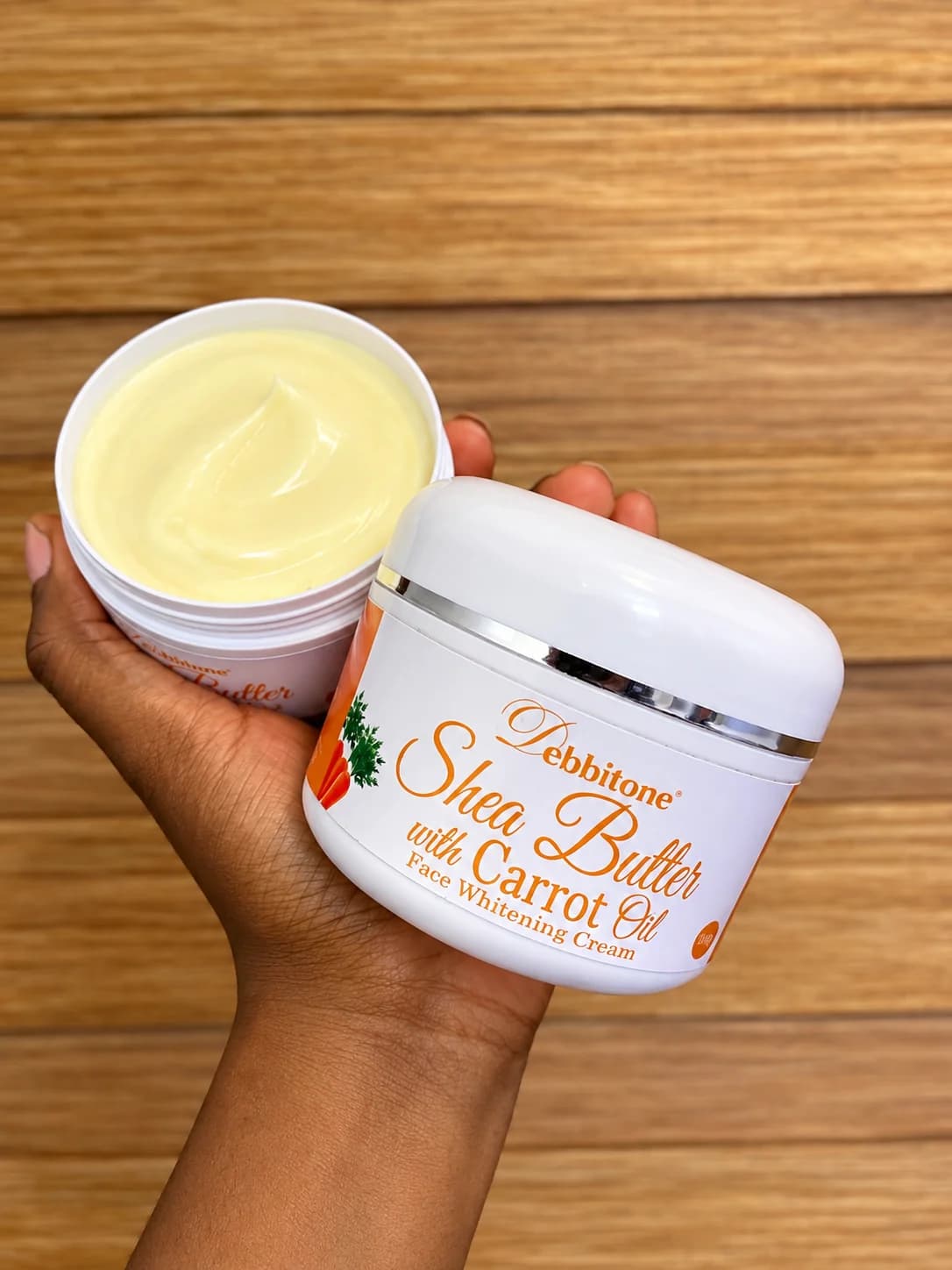 An open jar of Debbitone SheaButter Carrot Brightening Cream showing the rich cream inside